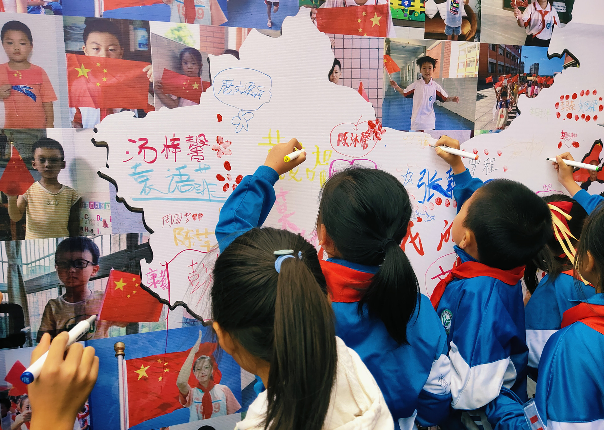同学们在中国地图上签名，表达对祖国的祝福。