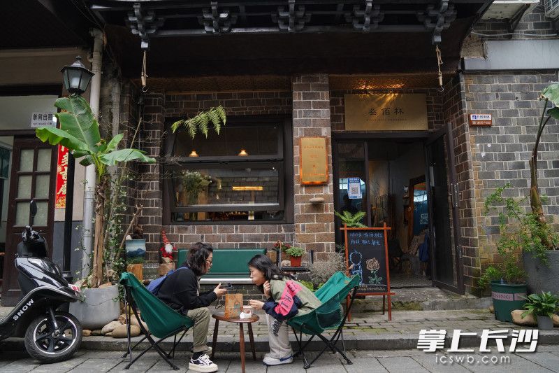 两位游客在潮宗街某咖啡店休息，享受悠闲时光。