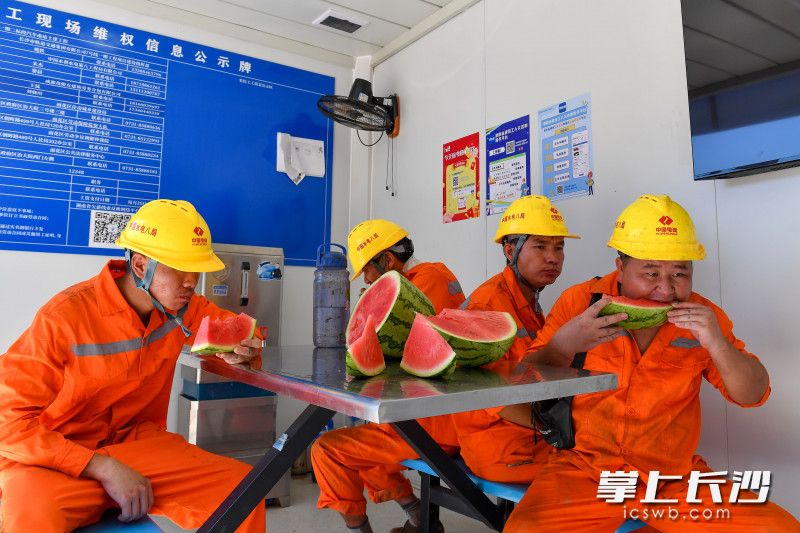 在7号线汽车南站休息区，施工人员在吃西瓜。
