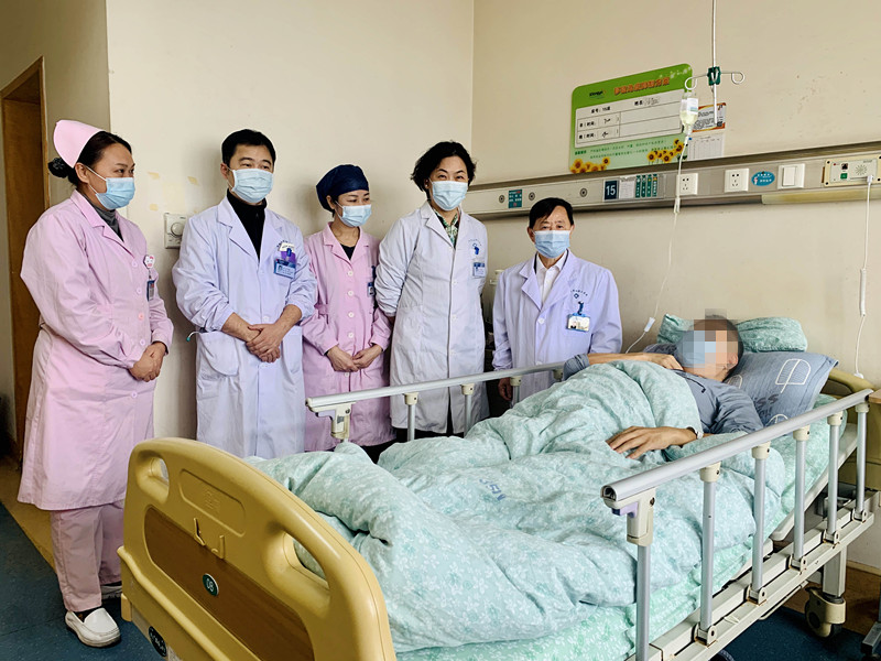 多学科医护团队在病房了解患者的术后病情，并叮嘱相关注意事项。