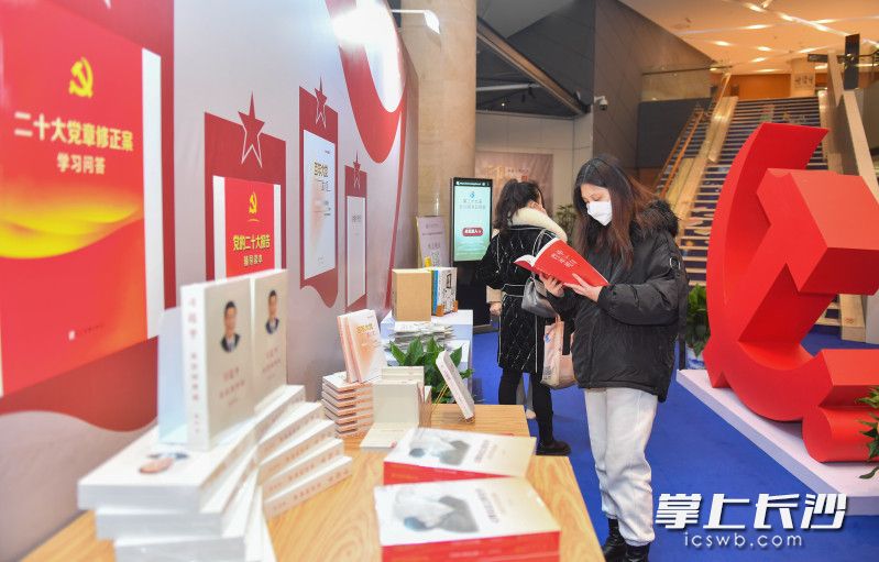 读者在习近平新时代中国特色社会主义思想及党的二十大主题出版物展区翻看书籍。
