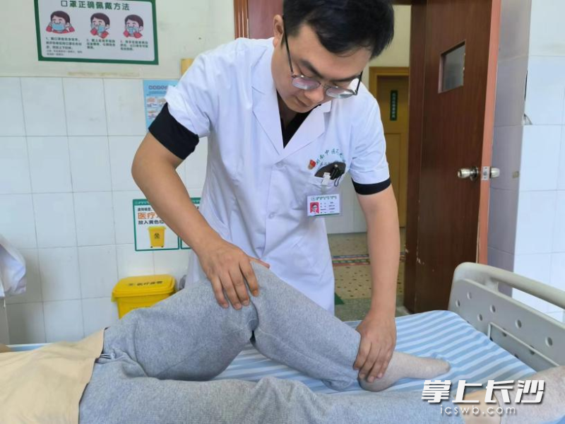 湖南中医药大学第二附属医院曾朋医生在为患者进行手法复位治疗，患者髌骨脱位复位后其膝关节已可正常活动。由医院供图