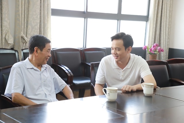 街道党工委书记胡汉堂（右）与邱炎生老师深入交流