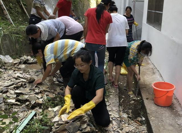 教师何小玲与志愿者一起清理校园建筑垃圾
