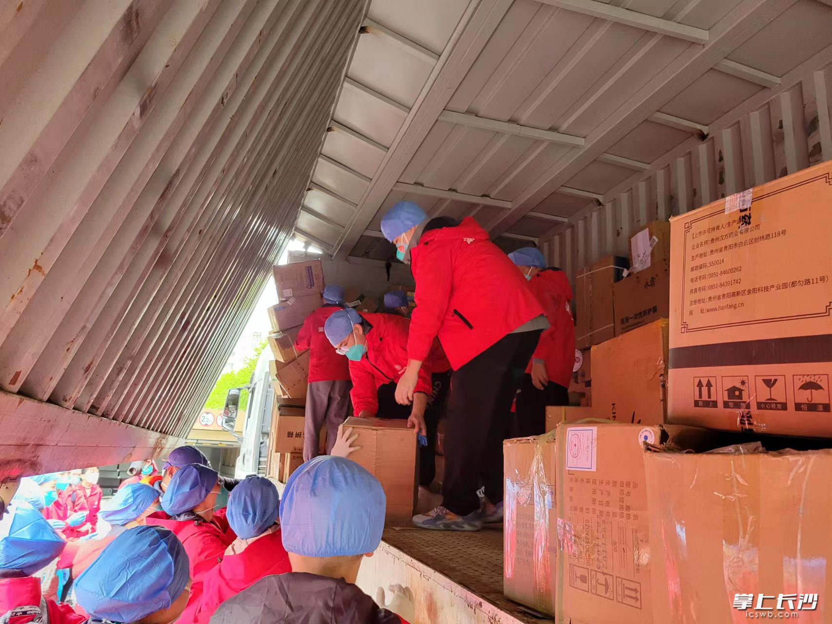湖南省中医院的援沪医疗队员帮助搬运湖南支援上海的爱心物资。 