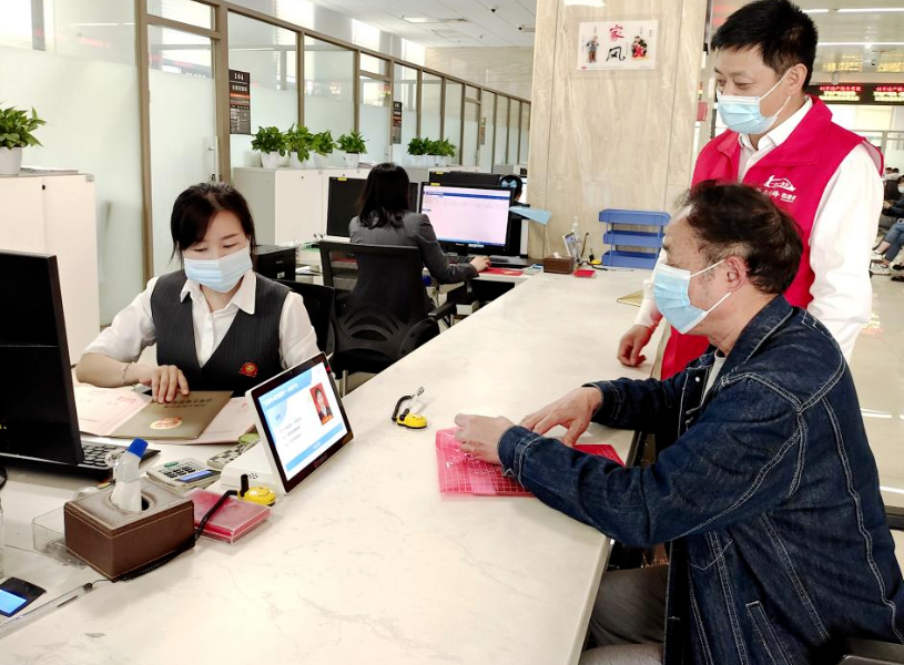 党员志愿者张京陪同办事群众办理业务。