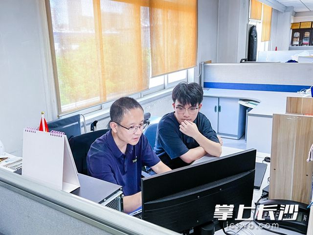 中南大学材料学专业罗逸豪（右）正与指导老师讨论实验数据。