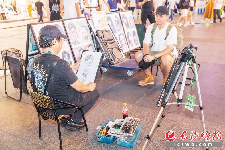 　　持证上岗的街头艺人正在给游客创作肖像画。