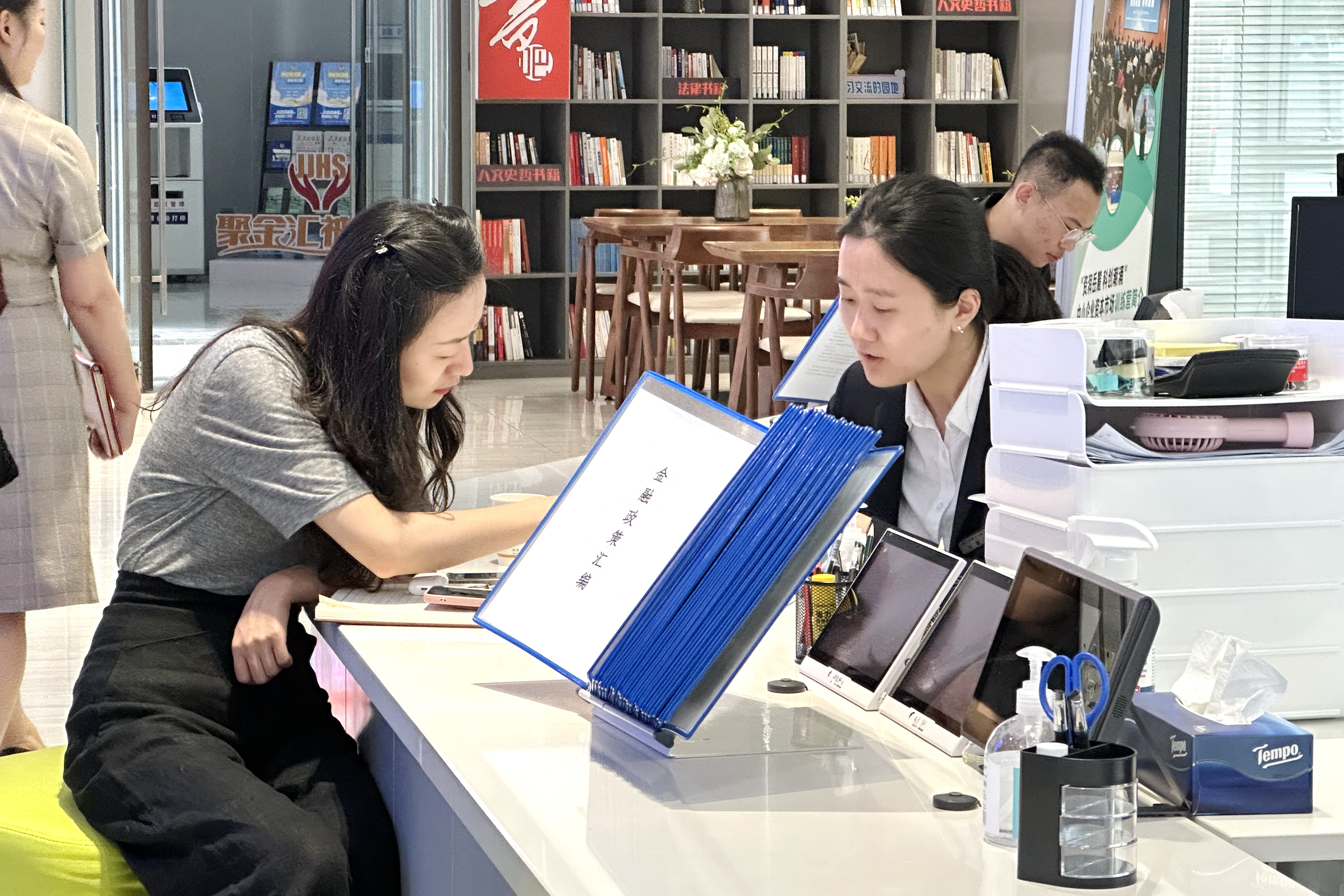 在湖南金融中心政务服务超市，企业代表在柜台前咨询新区金融政策。
